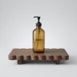 Original solid wood home decor rack with scalloped edge holding a soap dispenser and potted ivy