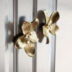 Gold orchid flower cabinet knobs on silver glass door