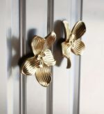 Gold orchid flower cabinet knobs on silver glass door