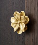 Gold magnolia flower cabinet knob on white drawer