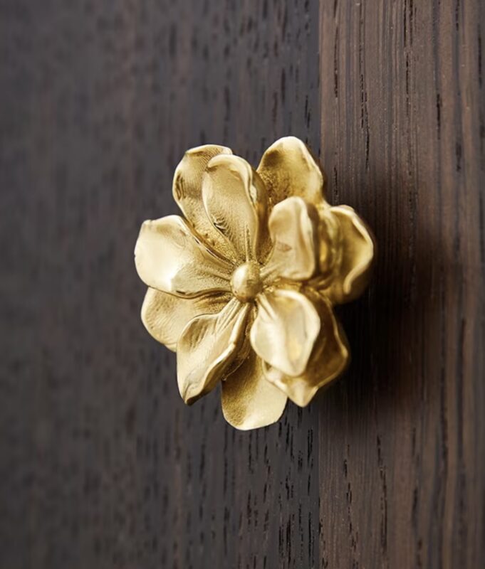 Gold magnolia flower cabinet knob on white drawer