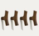 Four original solid wood cabinet handles with natural grain, mounted in a row on a white wall