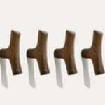 Four original solid wood cabinet handles with natural grain, mounted in a row on a white wall