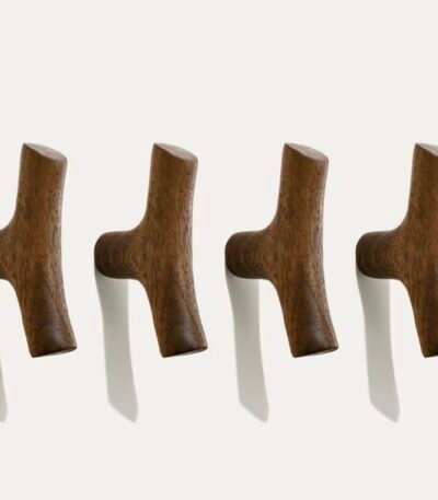 Four original solid wood cabinet handles with natural grain, mounted in a row on a white wall