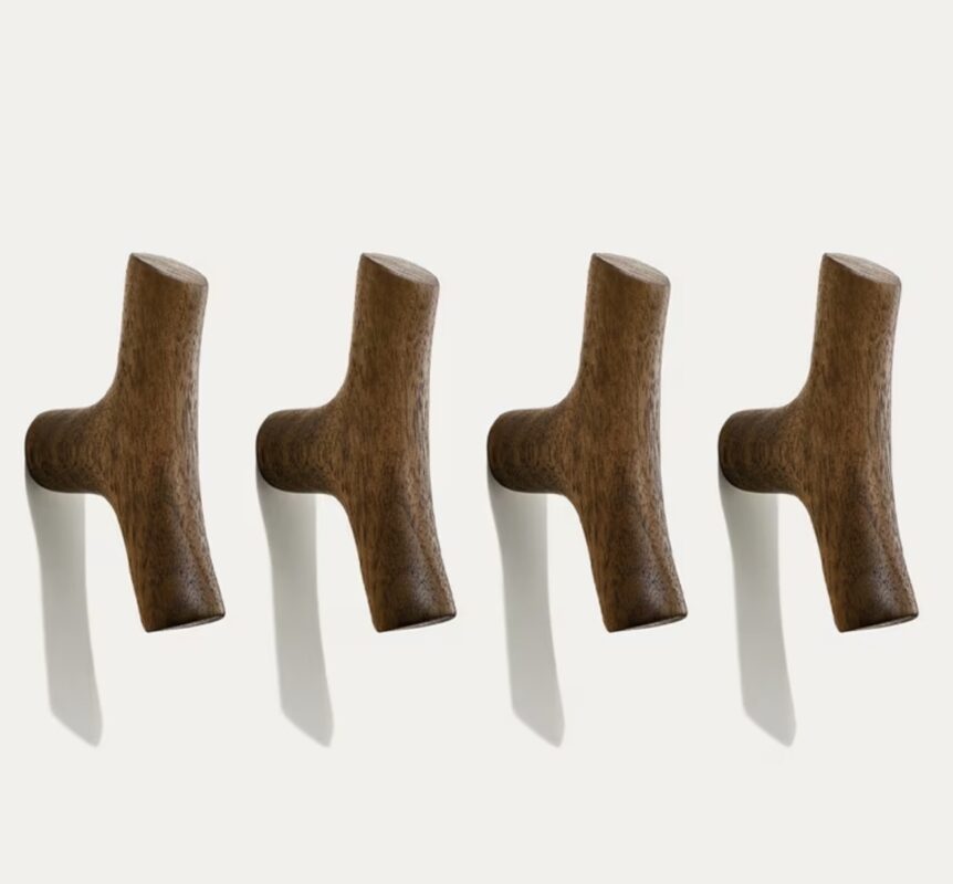 Four original solid wood cabinet handles with natural grain, mounted in a row on a white wall