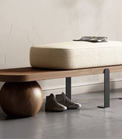 Walnut bench with sculptural sphere base, black steel legs and cream bouclé cushion in a modern entryway