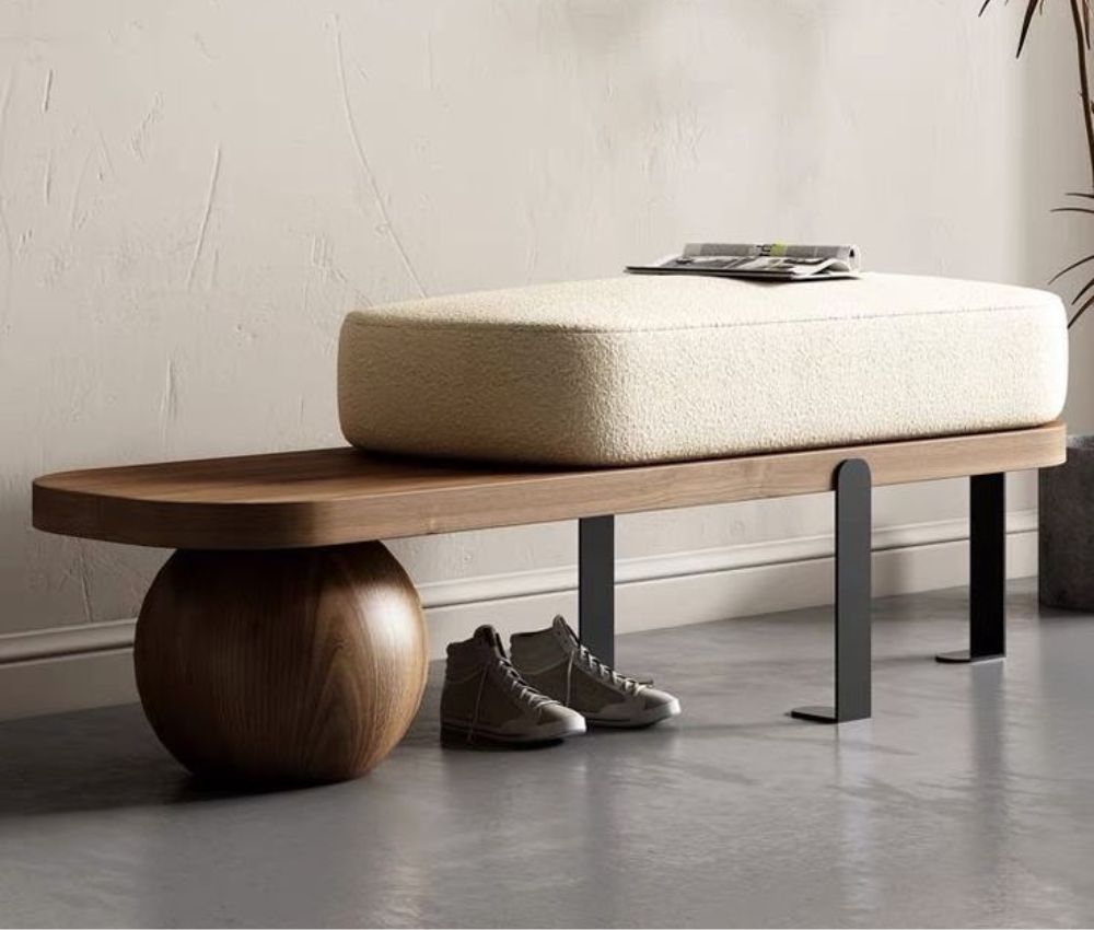 Orbit Walnut Bench with Bouclé Cushion Walnut bench with sculptural sphere base, black steel legs and cream bouclé cushion in a modern entryway