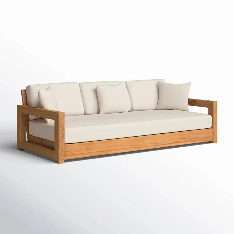 A contemporary outdoor daybed sofa crafted from light wood with plush, off-white upholstered cushions, featuring unique open-block armrests against a solid white background.